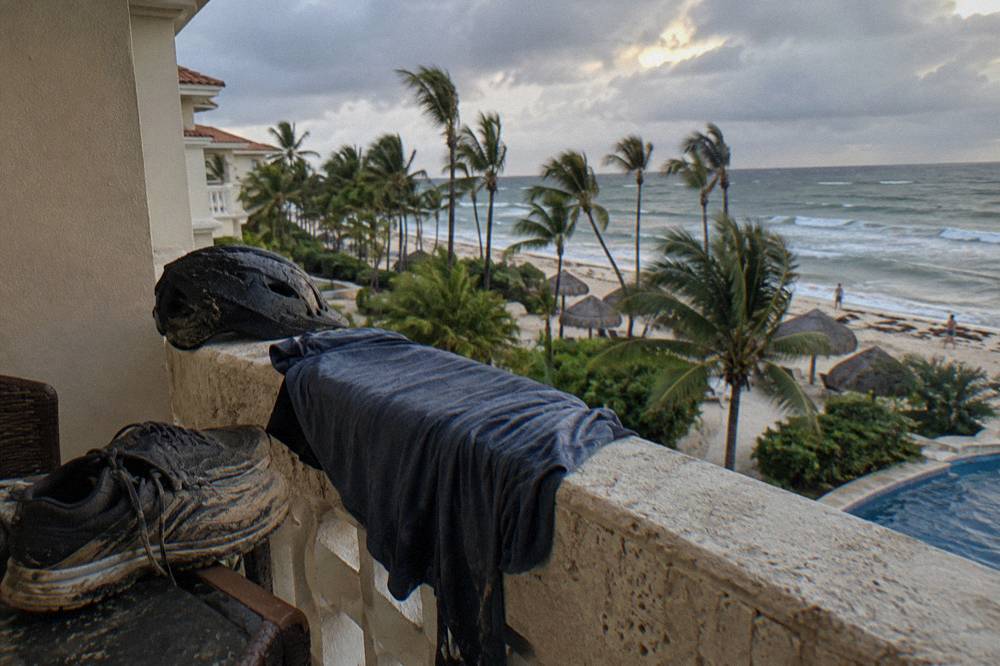 Sneakers and quick-dry clothing drying on a hotel balcony after a muddy excursion