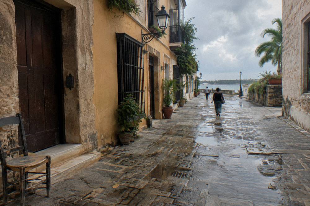 Cobblestone street lined with old stone buildings in a colonial city