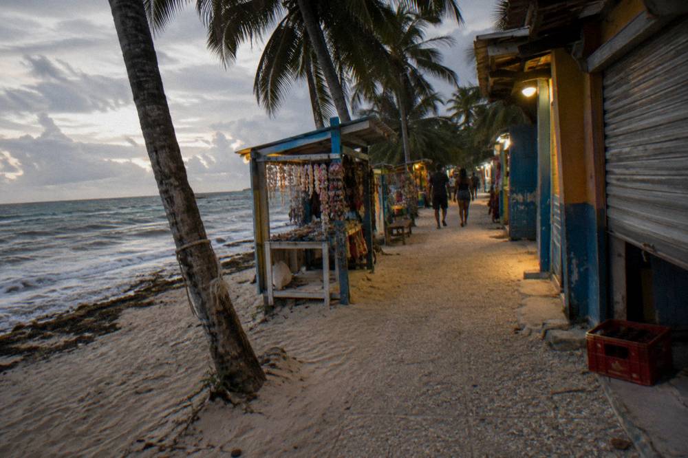 Small fishing boats anchored beside a calm Caribbean beach in Bayahibe