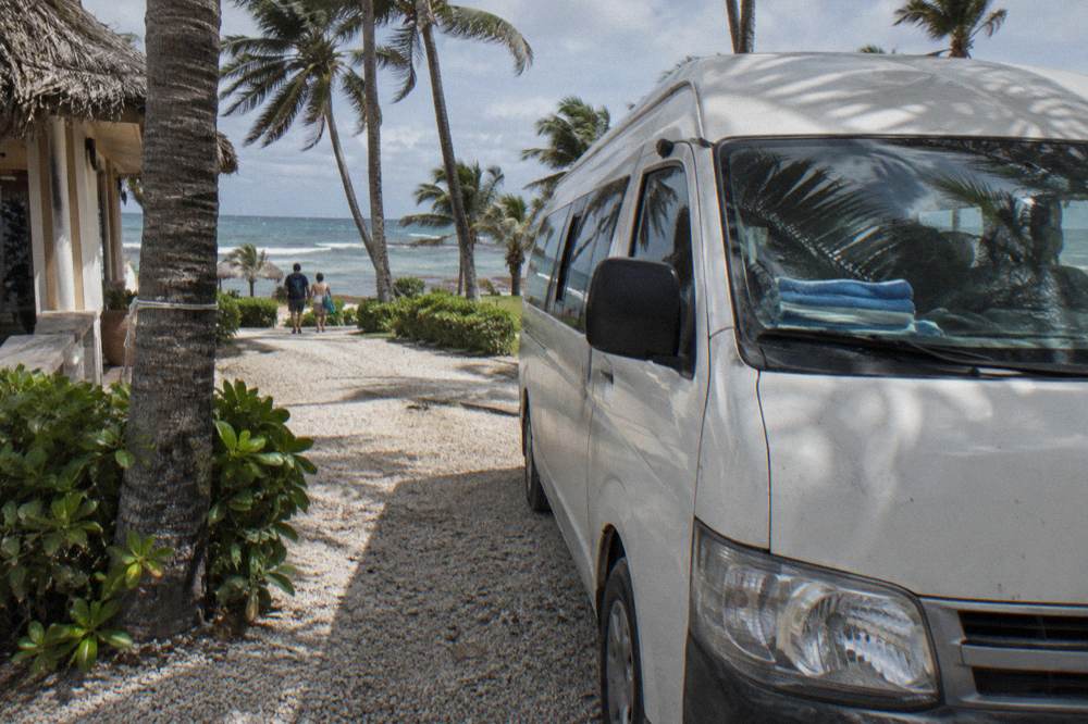 Tour van waiting at a resort driveway in the morning light
