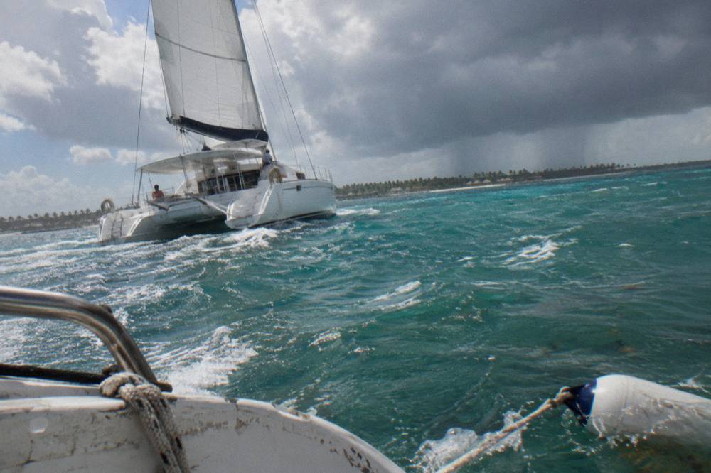 A private catamaran under sail on open turquoise water