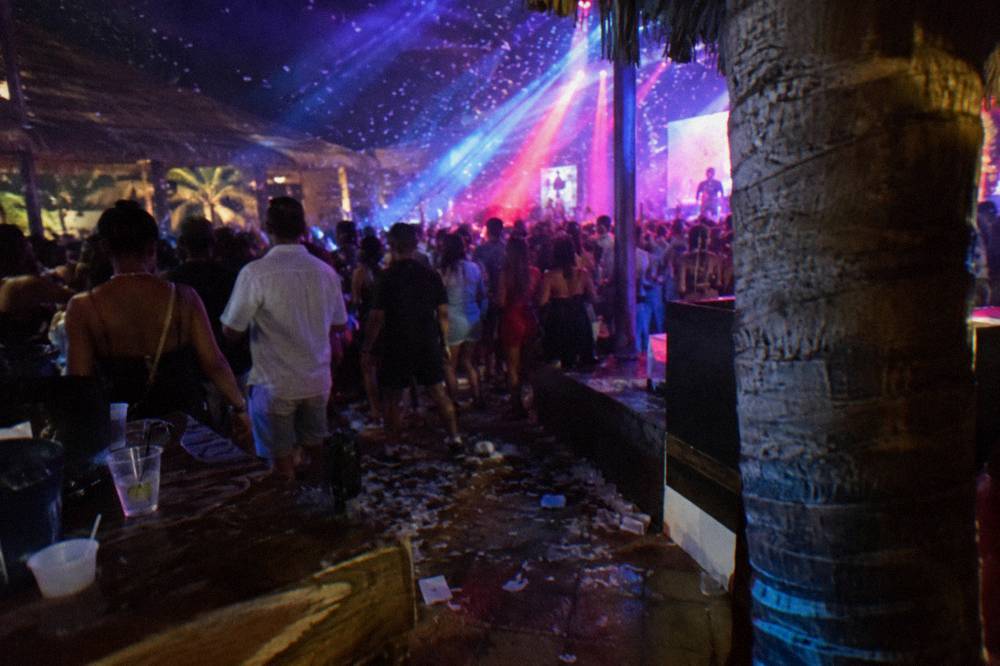 Stage lights and confetti falling over a dark crowded dance floor