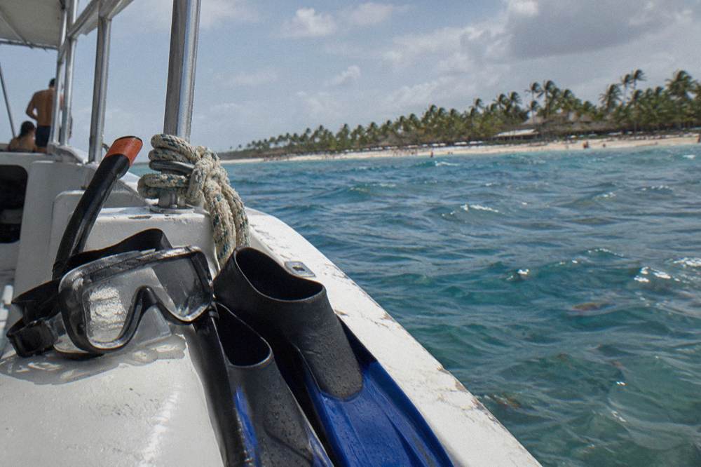 Snorkeling gear resting on a boat deck with clear blue water beyond the rail