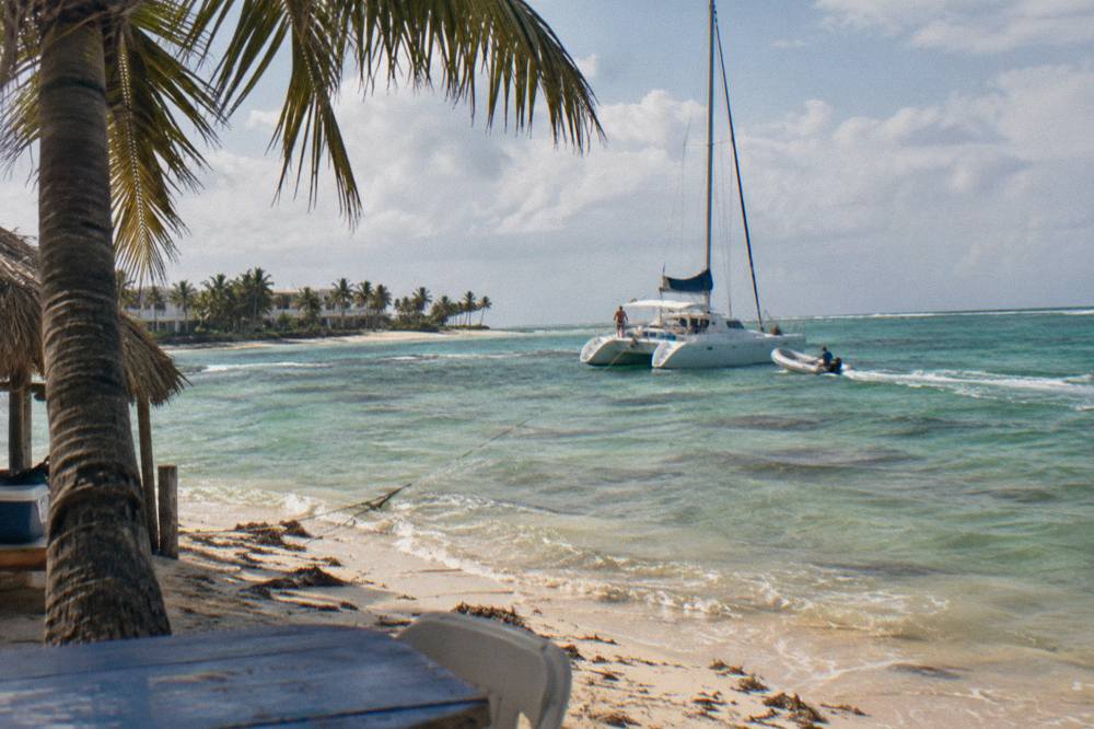 A catamaran anchored in shallow turquoise water near a coral reef