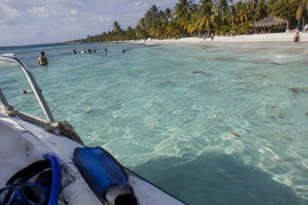Clear shallow water over a sandy bottom seen from a boat deck
