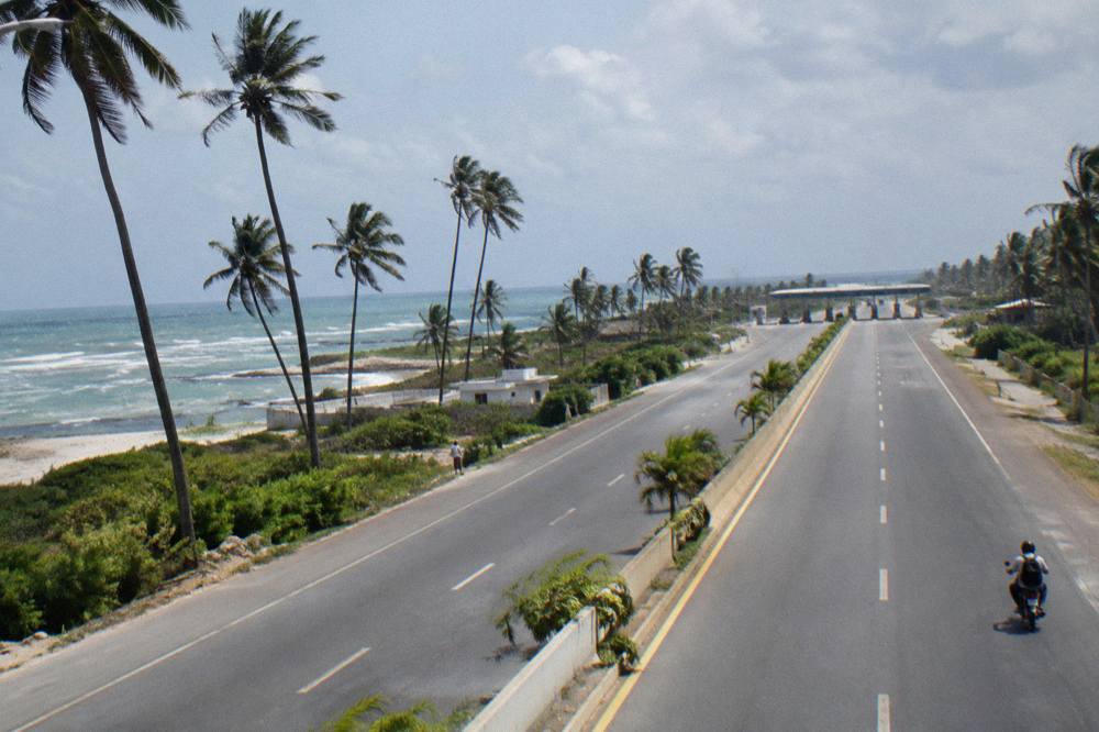 A divided tropical highway curving through green palm-dotted countryside