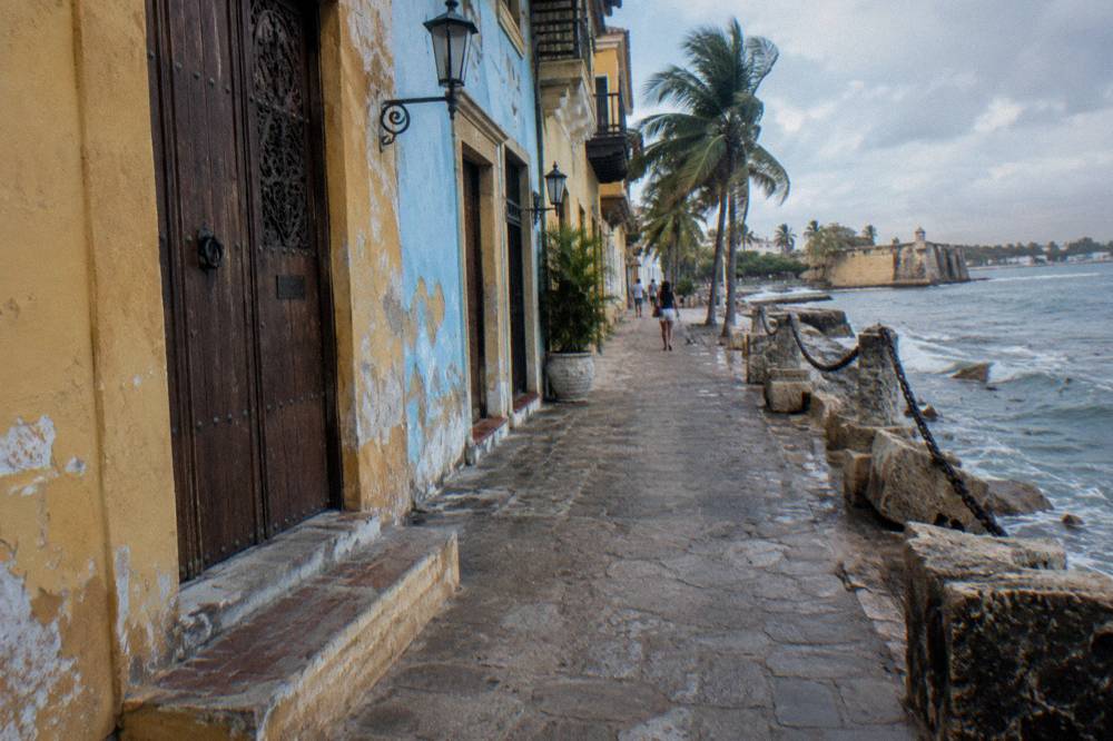 A colorful row of colonial storefronts with wooden doors and hanging lanterns