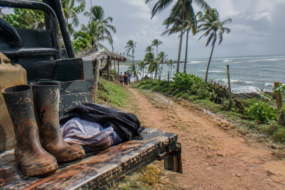 Pair of muddy boots and a folded change of clothes on the tailgate of an off-road vehicle
