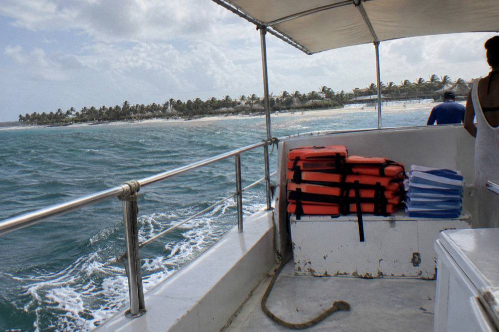 Shaded boat deck with life vests stacked and a stack of folded towels ready for passengers